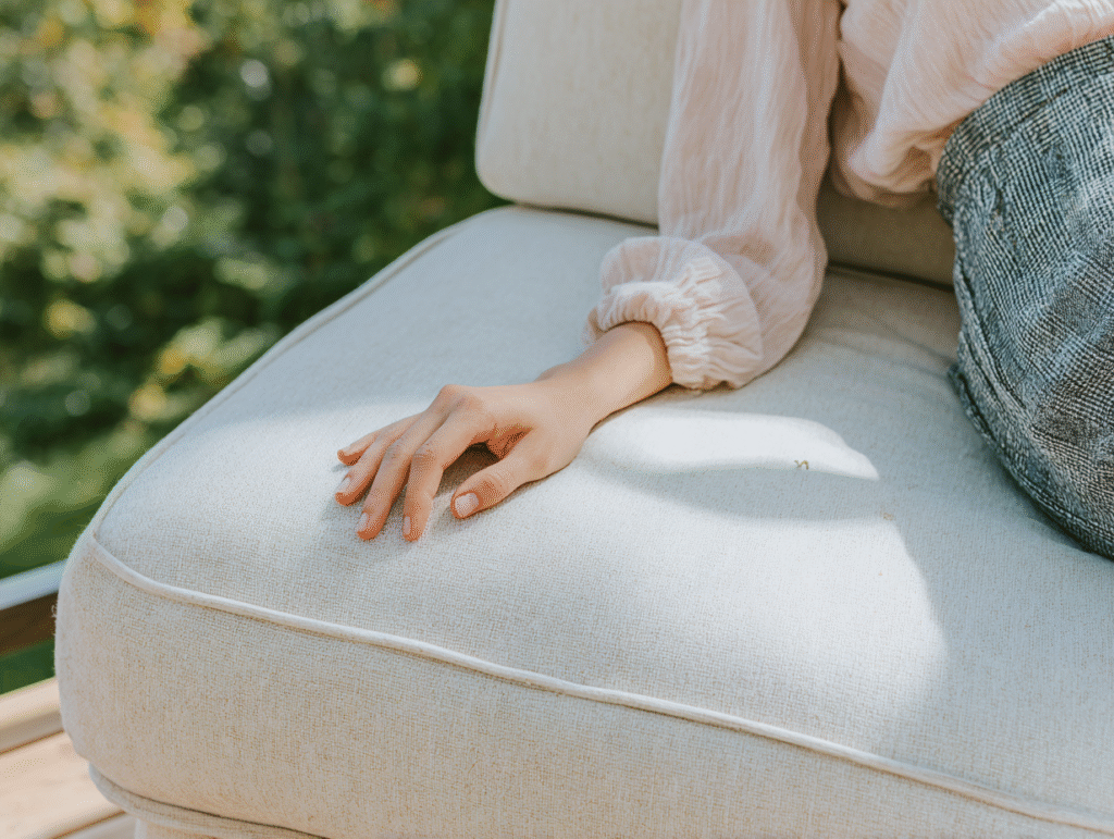 a woman lounges on an outdoor chaise lounge, focus on her hand