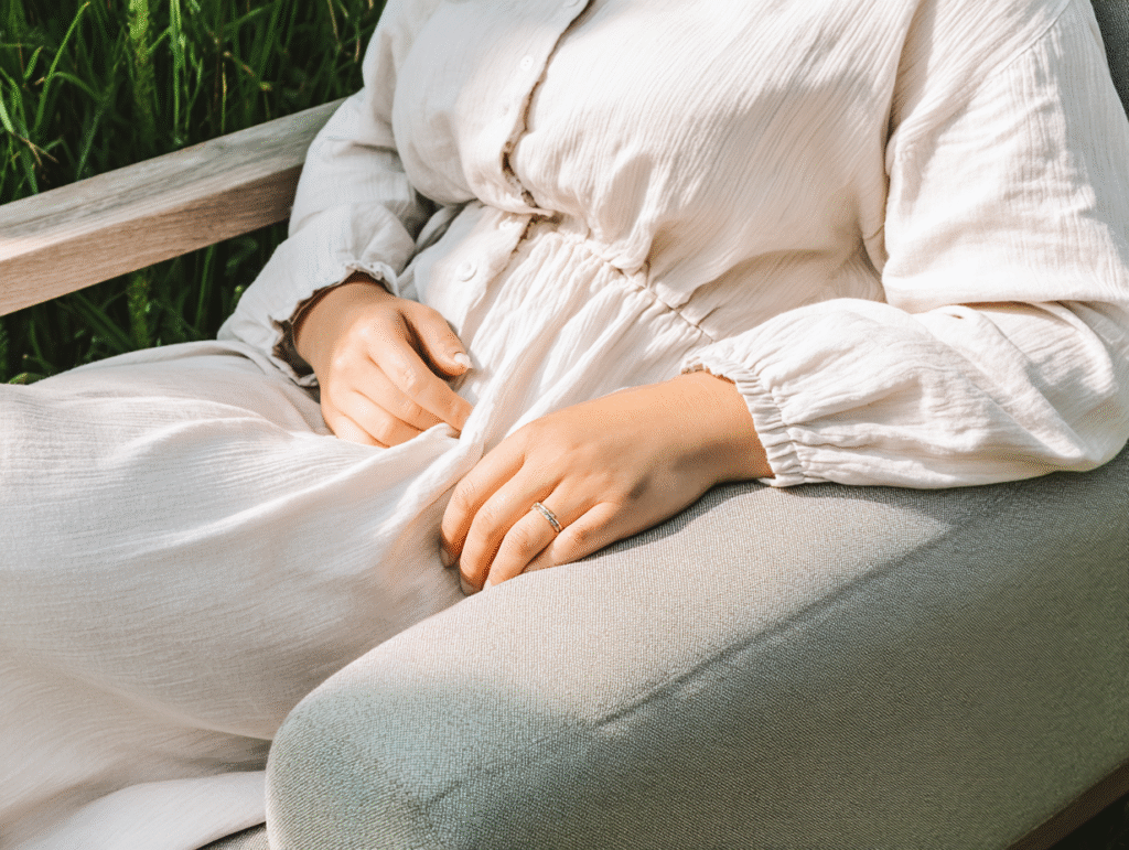 a woman lounges on a chair in an outdoor garden in a linen dress
