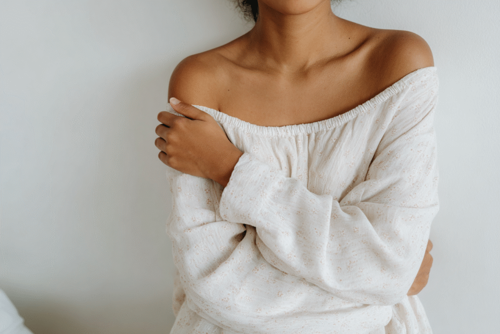 a woman gives herself a hug in a linen blouse