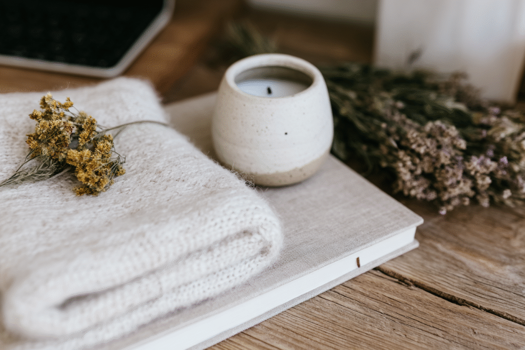 a candle, journal and towel on a table
