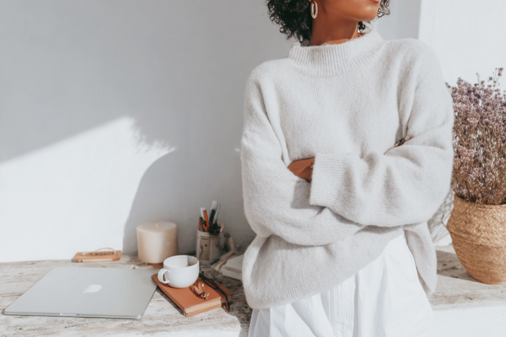 a woman stands by her workspace with closed laptop